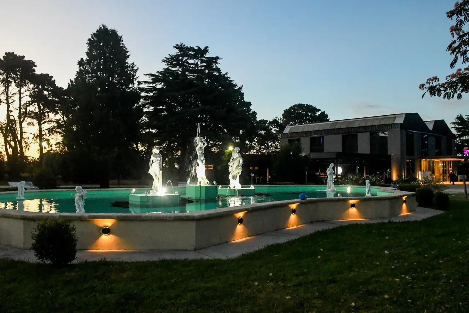 Parque y fuente iluminada al atardecer